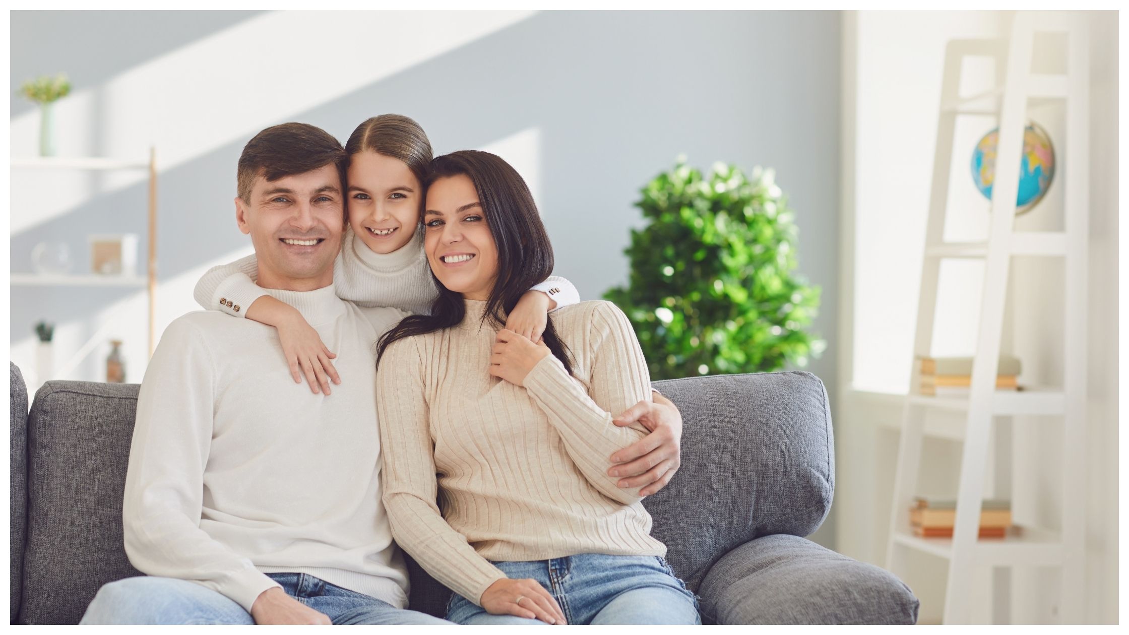 Happy Family at Home. Mother Father and Daughter Sitting on Sofa in Room.